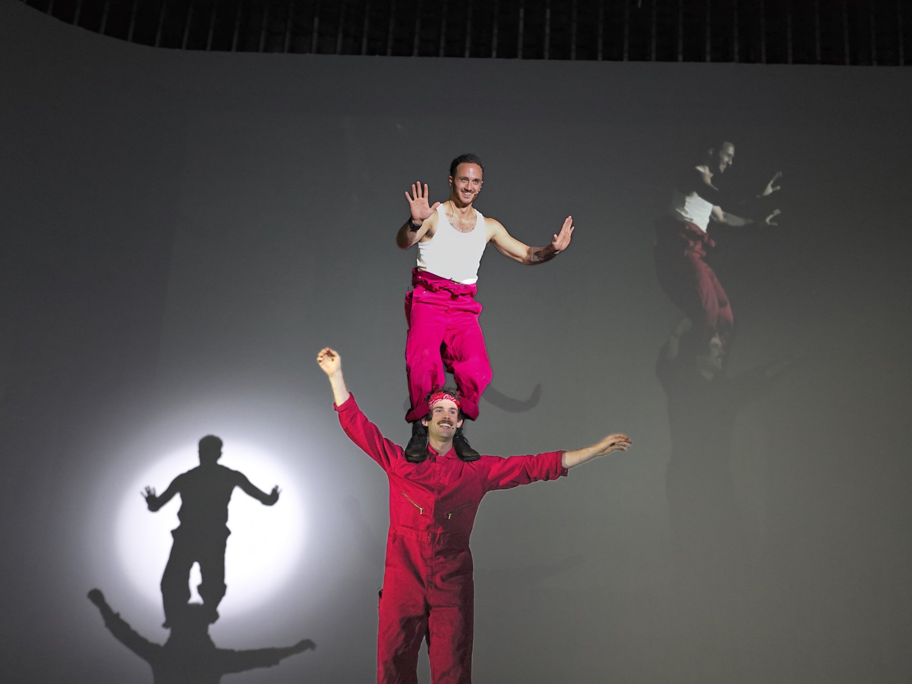 Two performers in red balancing on each other's shoulders at Filmshow Volume 1