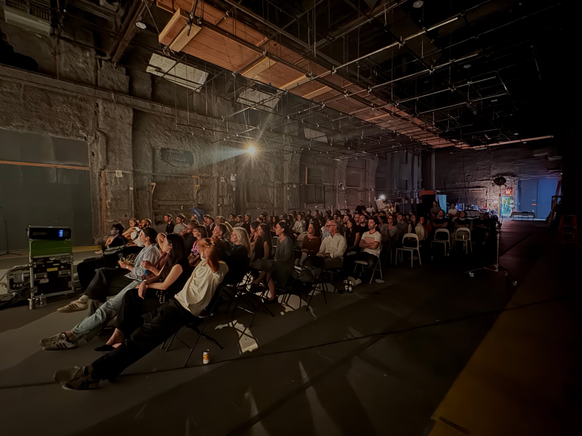 Audience seated for Filmshow in a warehouse screening space.